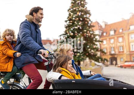 Giovane famiglia a cavallo in bicicletta da carico insieme Foto Stock