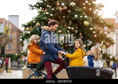 Giovane famiglia a cavallo in bicicletta da carico insieme Foto Stock