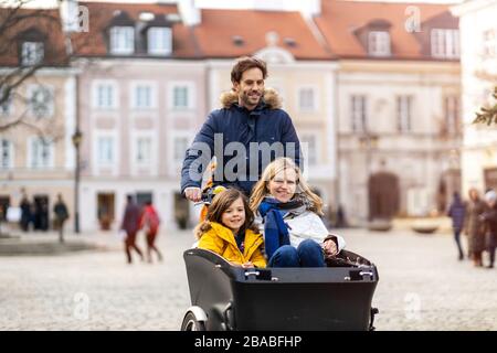 Giovane famiglia a cavallo in bicicletta da carico insieme Foto Stock