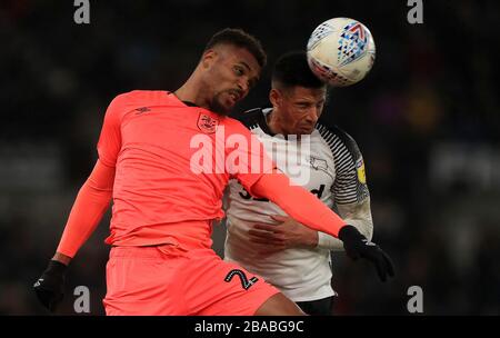 Steve Mounie di Huddersfield Town (a sinistra) e Curtis Davies di Derby County combattono per la palla Foto Stock