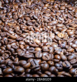 Lisi di chicchi di caffè marrone arrosto sul tavolo, vista frontale. Foto Stock