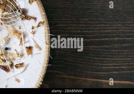 Pesce ossa su un unico piatto bianco. Sfondo del tavolo in legno con spazio copia Foto Stock