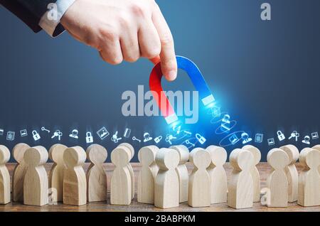 Una mano con un magnete raccoglie le password dei dati personali dalla folla. Raccolta di informazioni personali, sorveglianza spionaggio su utenti Internet. Furto Foto Stock