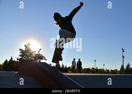 Silhouette di un ragazzo skateboard nello skatepark Foto Stock