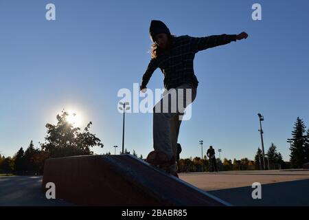 Silhouette di un ragazzo skateboard nello skatepark Foto Stock