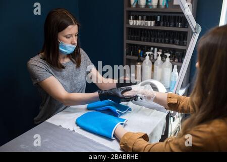 Salone Spa. Manicure. Bagno di paraffina. Trattamento della paraffina. Recipiente, additivo. Cura della vasca da bagno di cera. Cura delle unghie. Unghie artista che fa manicure Foto Stock