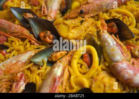 Primo piano di un piatto di fideuà, un piatto di tagliatelle, cozze e frutti di mare tipici della Spagna orientale Foto Stock