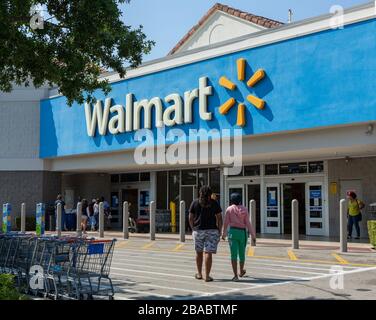 Persone vicino al negozio Walmart. Walmart è la terza società pubblica al mondo che gestisce catene di grandi magazzini. Tempo di coronavirus. Foto Stock