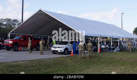 I membri della Guardia Nazionale della Florida dirigono i cittadini a un sito di prova basato sulla comunità COVID-19 presso il C. B. Smith Park 21 marzo 2020 a Pembroke Pines, Florida. Foto Stock