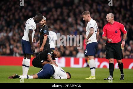 Raheem Sterling di Manchester City aiuta il DLE Alli di Tottenham Hotspur dopo la sua sfida durante la partita della Premier League al Tottenham Hotspur Stadium di Londra. Foto Stock