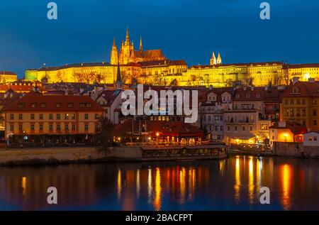 Castello di Praga, noto anche come Castello di Hradcany, di notte lungo il fiume Moldava e la cattedrale di San Vito in cima, Repubblica Ceca. Foto Stock