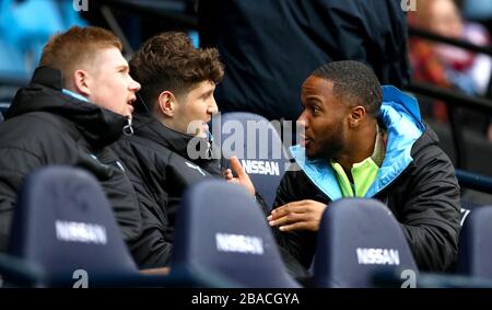 Raheem Sterling (a destra) di Manchester City parla con i compagni di squadra John Stones e Kevin De Bruyne Foto Stock