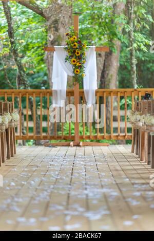 Scatto verticale di una bella navata esterna di nozze con decorato con fiori gialli Foto Stock