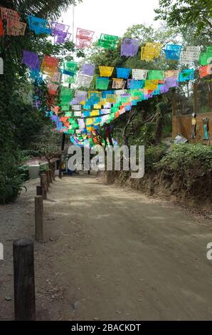 Papel picado appesa sulla strada che conduce a Playa Los Muertos, Sayulita, Nayarit, Messico. Foto Stock