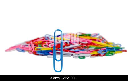 Clip in carta blu verticale davanti un gruppo di clip in carta multicolore su sfondo bianco sfocato e isolato, con immagine concettuale su un leader Foto Stock
