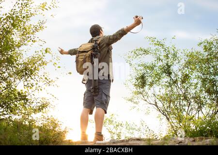 Giovane cinese in piedi sulla cima della montagna Foto Stock