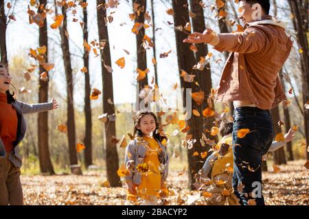 Famiglie felici all'aperto e foglie Foto Stock