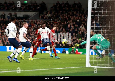 Il portiere di Tottenham Hotspur Paulo Gazzaniga (a destra) fa un salvataggio dalla palla capeggiata da Sadio Mane di Liverpool (a sinistra nascosta) Foto Stock