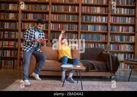 Due giovani uomini che studiano prima degli esami e che guardano annoiato Foto Stock
