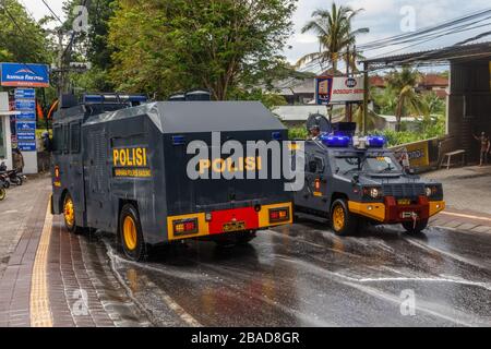 27 marzo 2020. Le unità di mobilitazione della polizia puliscono le strade per spruzzare disinfettante sulle strade di Canggu, Bali popolare zona turistica. Indonesia. Foto Stock