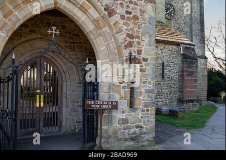 L'ingresso con il cartello 'ora aperto' per la chiesa di St Mary a Horsham, West Sussex, Inghilterra. Foto Stock