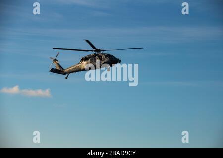 PHILIPPINE SEA (23 marzo 2020) un elicottero Sea Hawk MH-60S assegnato al "Island Knights" di elicottero Sea Combat Squadron (HSC) 25 si prepara a atterrare sul ponte di volo della nave d'assalto anfibio USS America (LHA 6) durante un esercizio di difesa aerea. America, fiore all'occhiello dell'America Expeditionary Strike Group, il 31° team MEU, opera nell'area operativa della settima flotta statunitense per migliorare l'interoperabilità con alleati e partner e funge da forza di risposta pronta per difendere la pace e la stabilità nella regione dell'Indo-Pacifico. (Foto ufficiale del corpo marino degli Stati Uniti di CPL. Isaac Cantrell) Foto Stock