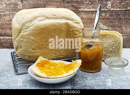 Pane fatto in casa appena sfornato con marmellata di albicocche. Foto Stock