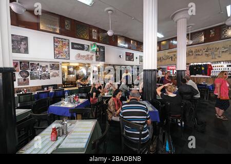 Clienti del popolare ristorante vecchio stile il Leopold Cafe Colaba a Mumbai, India Foto Stock