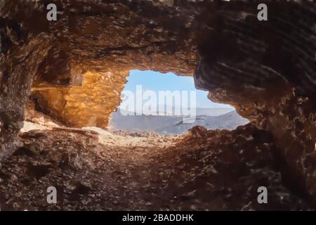 Vista dall'interno di una grotta al deserto roccioso nel Sahara nel Sudan che giace sotto un sole splendente. Foto Stock