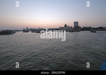 Taj Mahal Hotel, Gateway of India e barche turistiche in acqua del Mar Arabico al tramonto a Mumbai, India Foto Stock