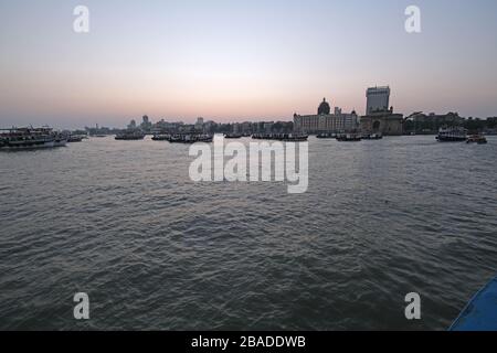 Taj Mahal Hotel, Gateway of India e barche turistiche in acqua del Mar Arabico al tramonto a Mumbai, India Foto Stock