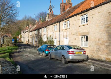 Cottage in pietra tradizionale a schiera a Helmsley, North Yorkshire, in un pomeriggio soleggiato Foto Stock