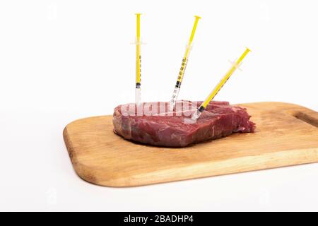 Siringhe in carne cruda su tagliere di legno isolate su bianco Foto Stock