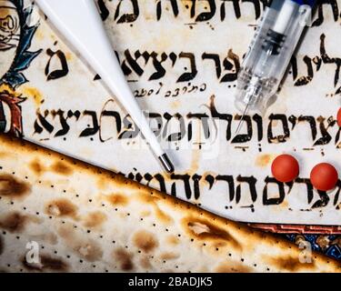 Un Passover Seder all'ombra del virus Corona COVID-19. Matza, pillole, e un'iniezione. Foto Stock