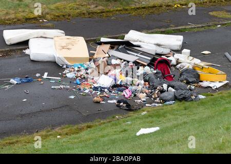 Fly Tucing uk - grande mucchio di rifiuti domestici, compresi giocattoli e materassi per bambini - Easterhouse, Glasgow, Scozia, Regno Unito Foto Stock