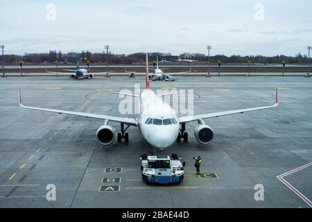 Vista del parcheggio dell'aereo all'aeroporto. L'aereo è in fase di preparazione per la partenza da parte del personale dell'aeroporto Foto Stock
