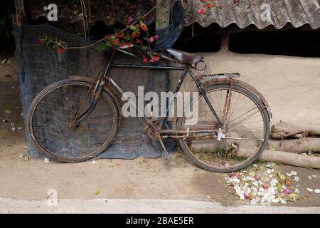 Bicicletta appoggiata al muro a Kumrokhali, Bengala Occidentale, India Foto Stock
