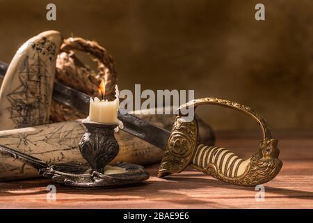 Stlll vita del 19th secolo mare viaggio con un attacco su un tusk di waltus, corda, sciabola navale inglese e candela bruciante Foto Stock