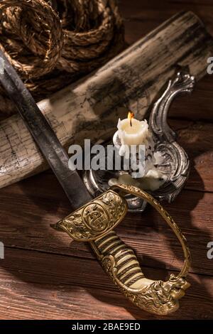 Stlll vita del 19th secolo mare viaggio con un attacco su un tusk di waltus, corda, sciabola navale inglese e candela bruciante Foto Stock