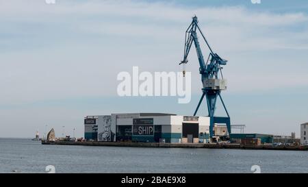 Aarhus, Danimarca - 24 marzo 2020: Gru a portale in piedi sulla banchina al porto di Aarhus accanto ad esso si trova il vecchio molo galleggiante Foto Stock