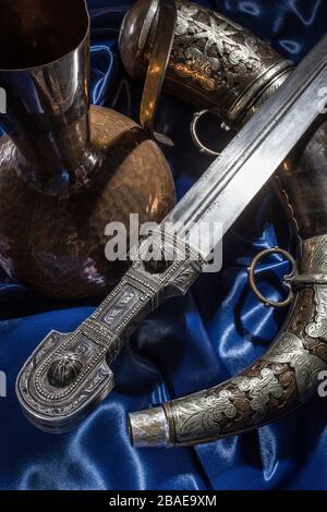 Bell'esempio di pugnale caucasico con matraccio in polvere d'argento su sfondo di seta blu. 19th secolo (tempo delle guerre russo-caucasiche (1816-1864)). RUS Foto Stock