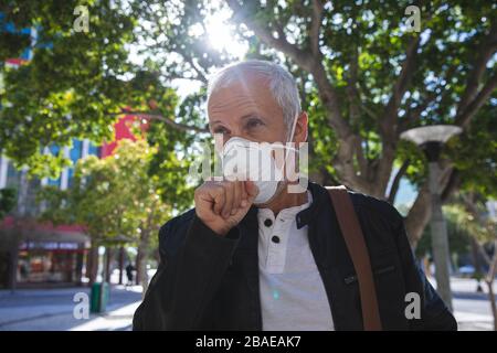 Uomo di mezza età che indossa la maschera di coronavirus Covid 19 in movimento Foto Stock