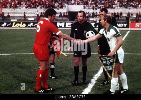 Il capitano di Liverpool Emlyn Hughes (l) scrolla le mani con il capitano Borussia Monchengladbach Berti Vogts (r) prima della partita, guardato dall'arbitro Robert Wurtz (c) Foto Stock