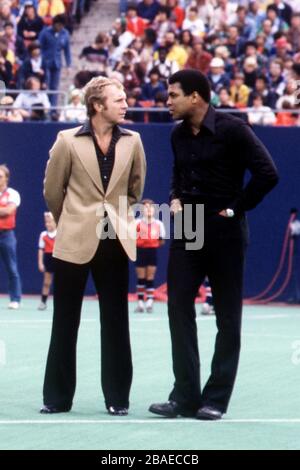 (L-R) l'ex capitano dell'Inghilterra Bobby Moore ha chattato al campione mondiale di boxe Heavyweight Muhammad Ali mentre aspettano di dare il benvenuto a Pele sul campo per la partita finale della sua carriera Foto Stock