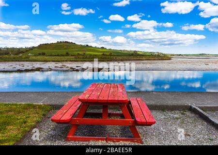 Panchina rossa nella campagna irlandese della zona di Cork Foto Stock