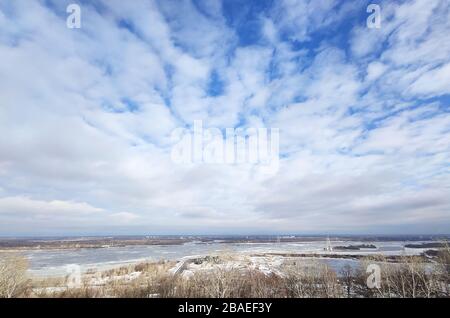 Bellissimo paesaggio del fiume delle prime sorgenti. Nuvole bianche sul fiume e alberi in un giorno di sole dopo aver fuso la neve. Foto Stock