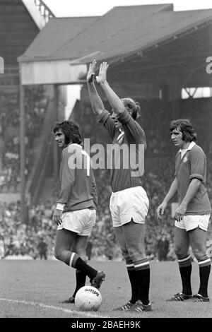 Bobby Charlton (c) del Manchester United segnala i suoi progressi mentre si prepara a prendere un calcio di punizione, guardato dai compagni di squadra George Best (l) e Ian Story-Moore (r) Foto Stock