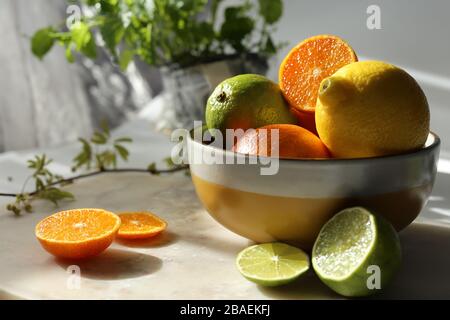 Ancora vita con frutta e menta arancione su piano in marmo bianco e tela. Foto Stock