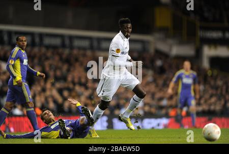 Zeljko Filipovic di Maribor (a sinistra) sul pavimento mentre Emmanuel Adebayor di Tottenham Hotspur corre con la palla Foto Stock