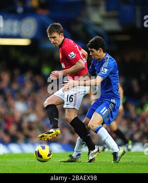 Emboaba Oscar di Chelsea (a destra) e Michael Carrick del Manchester United (a sinistra) combattono per la palla Foto Stock